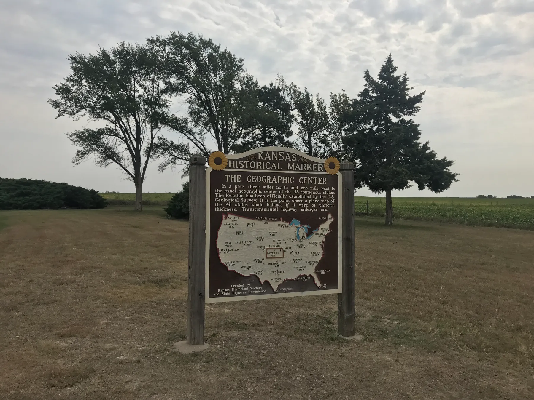 The Kansas geographic center historical marker in an open field.