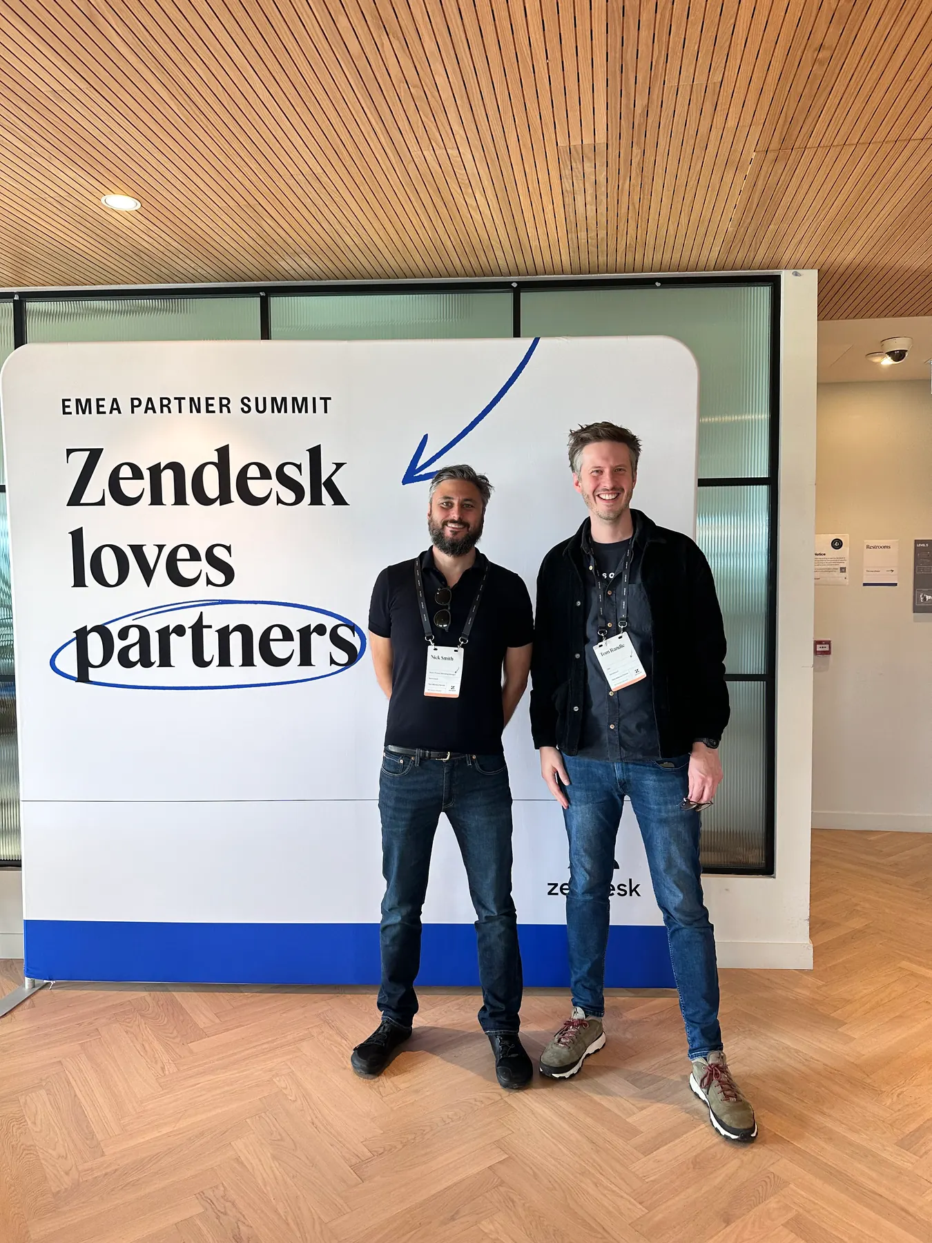 Two people standing in front of a Zendesk loves partners sign at the EMEA Partner Summit in Dublin.
